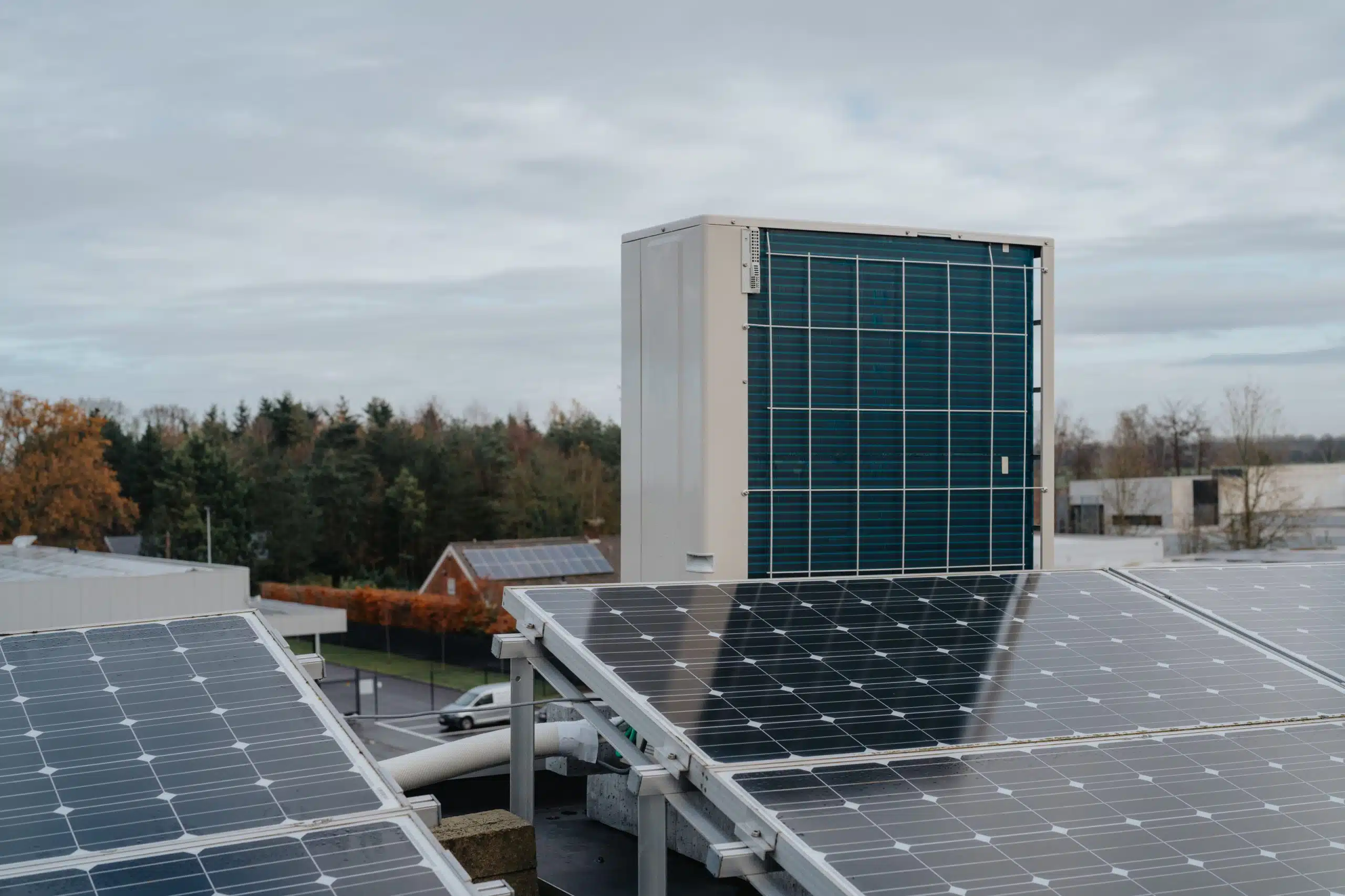 Zonnepanelen installatie op bedrijfsdak met warmtepomp systeem en batterijopslag voor duurzame energieopwekking