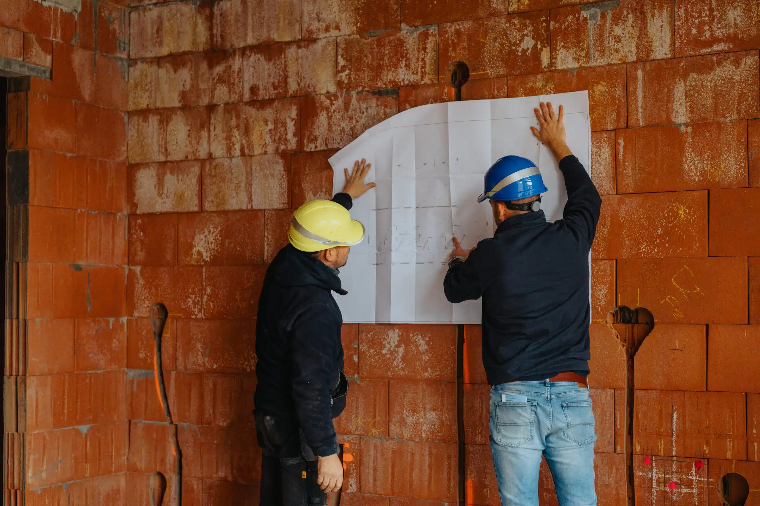 Willemsen Technieken monteurs installeren airco systeem aan muur met bouwplan