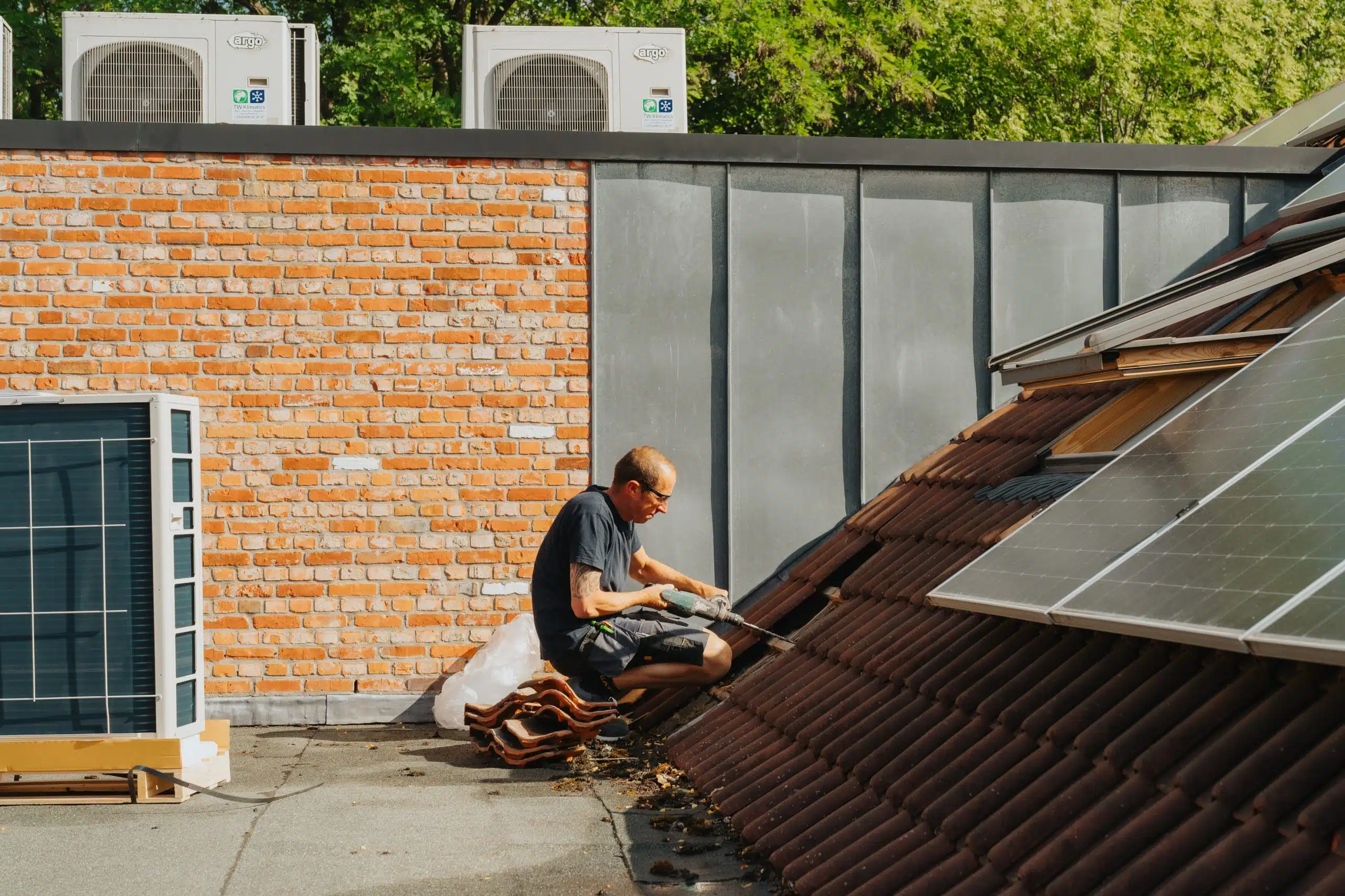 Airco technicus voert onderhoud uit aan dakinstallatie met Ergo warmtepomp unit op dak