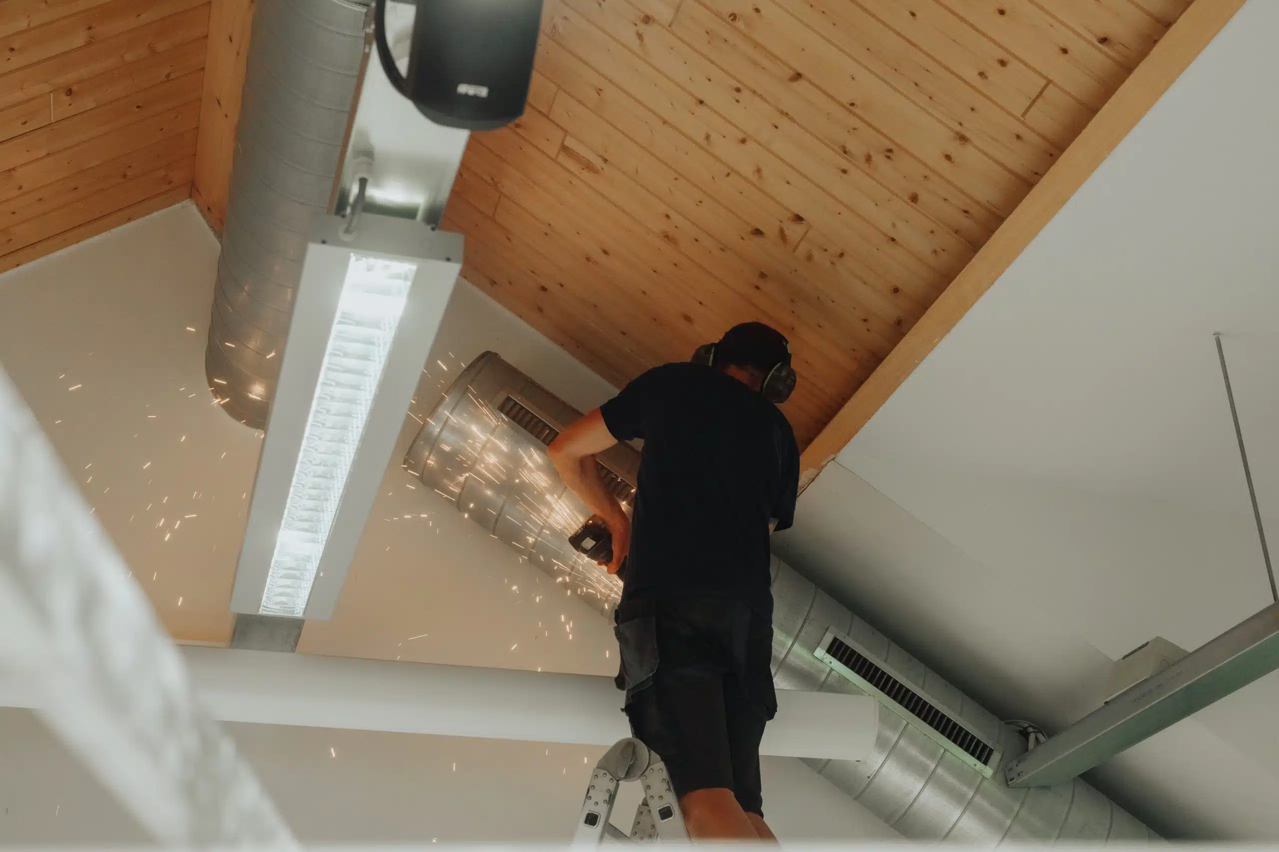 Technicus installeert en onderhoudt ventilatie-unit aan plafond in woning