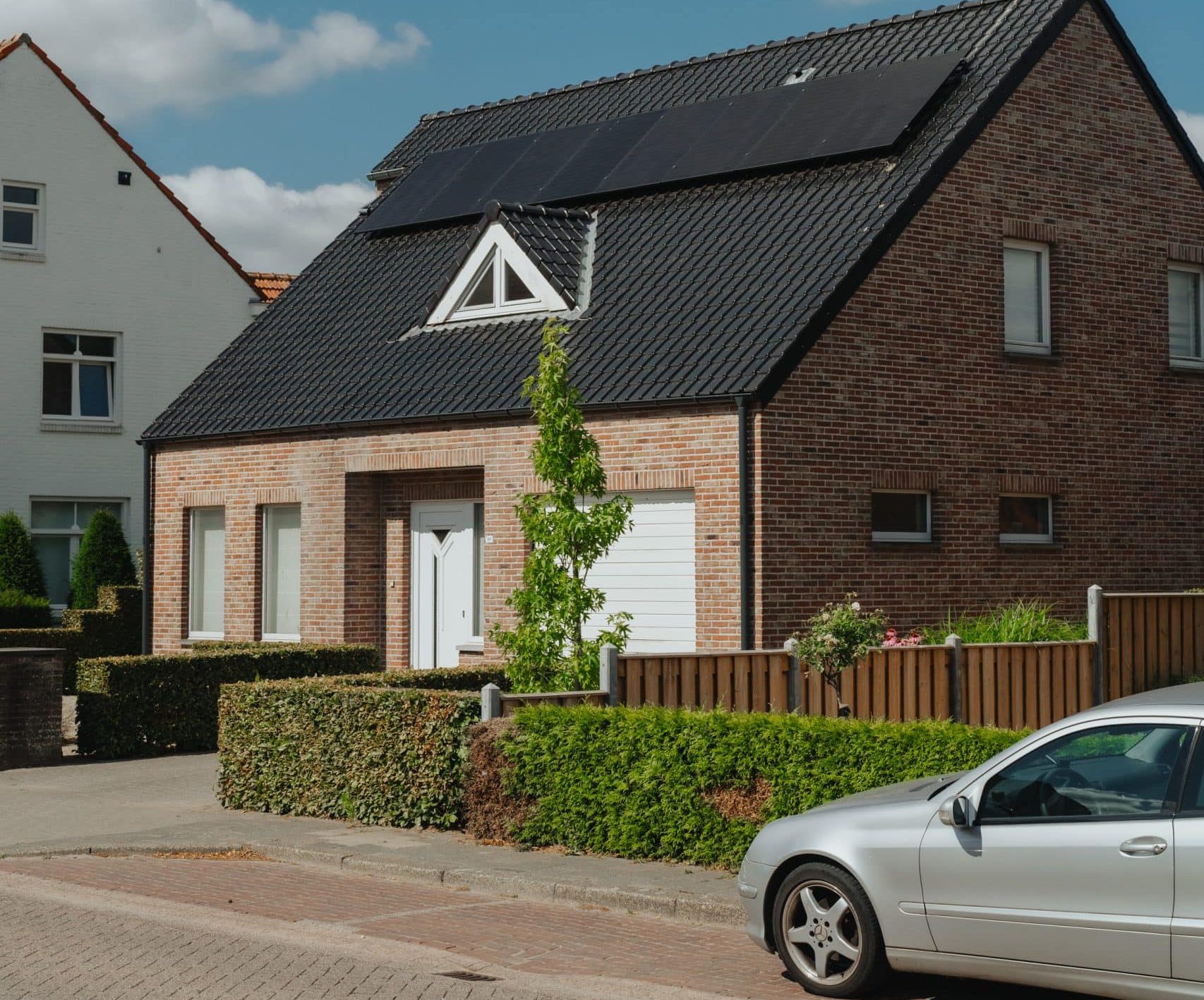 Bakstenen huis met zonnepanelen op het zwarte dak.