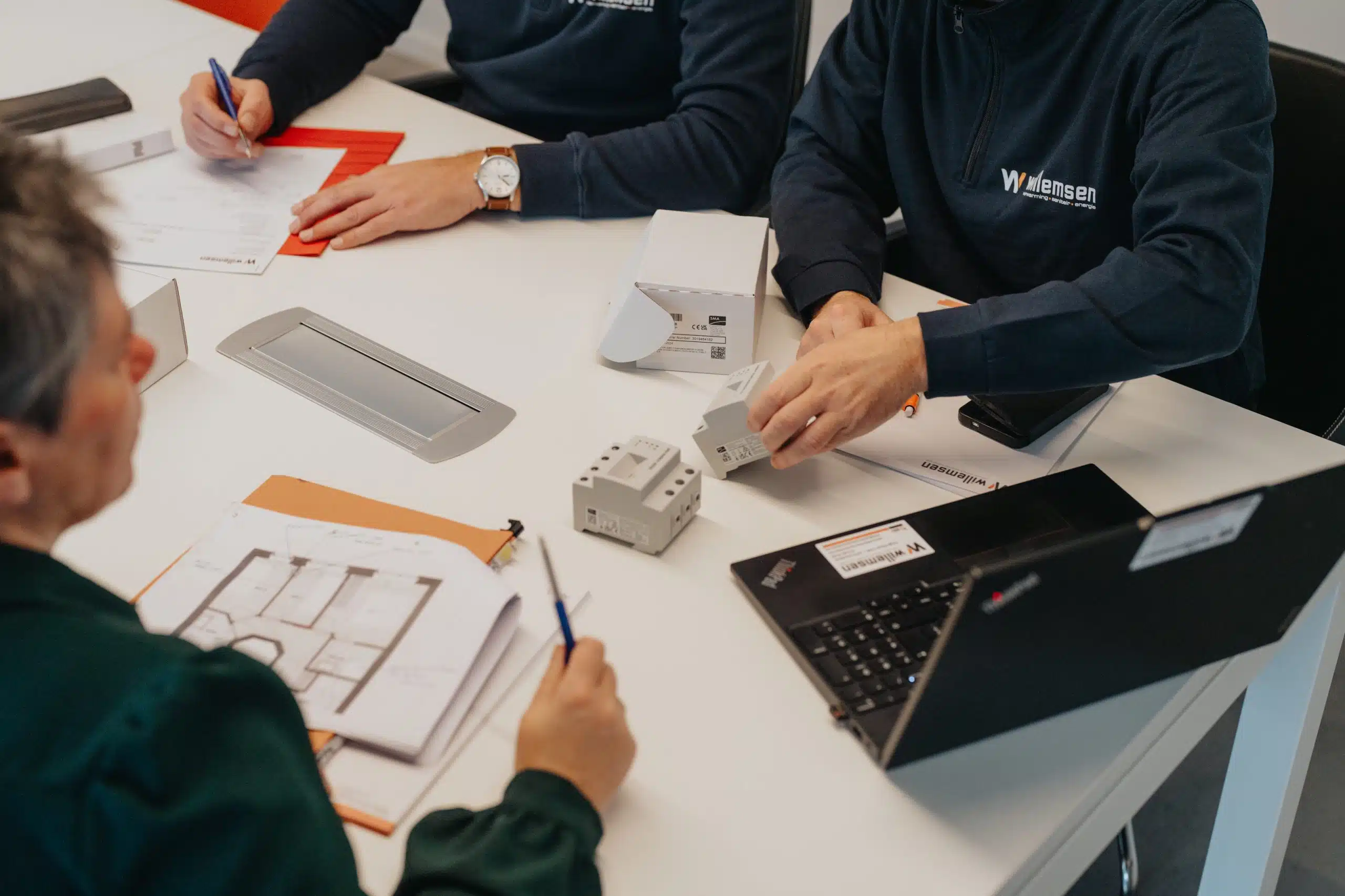 Willemsen Technieken experts bespreken zonnepanelen installatie en energieoplossing met technische tekeningen