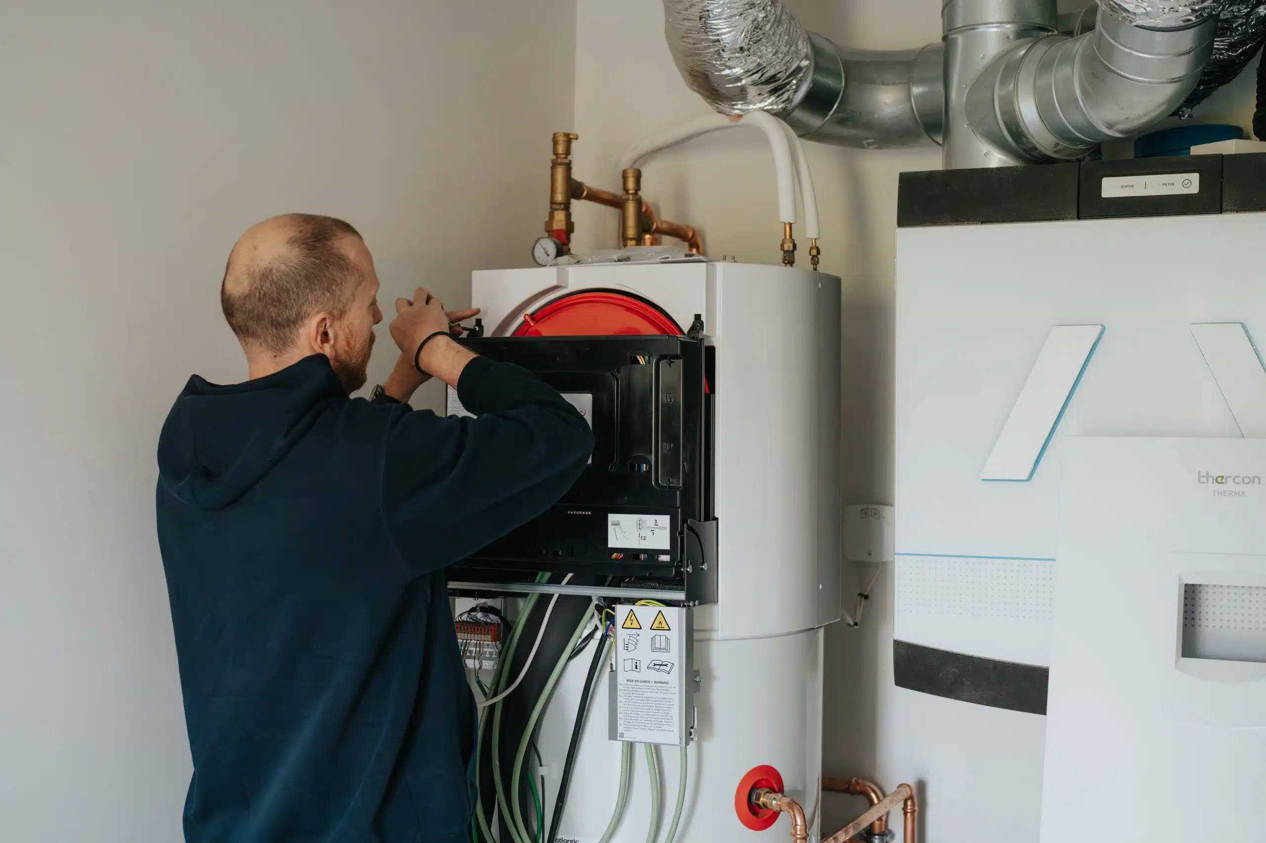 Technicus voert onderhoud uit aan moderne ventilatie-installatie voor gezond binnenklimaat