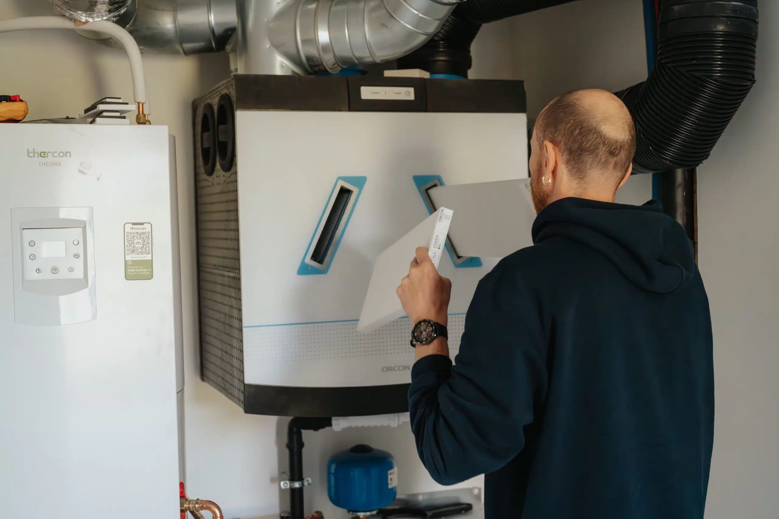 Technicus voert onderhoud uit aan Orcon ventilatie-installatie met luchtkanalen