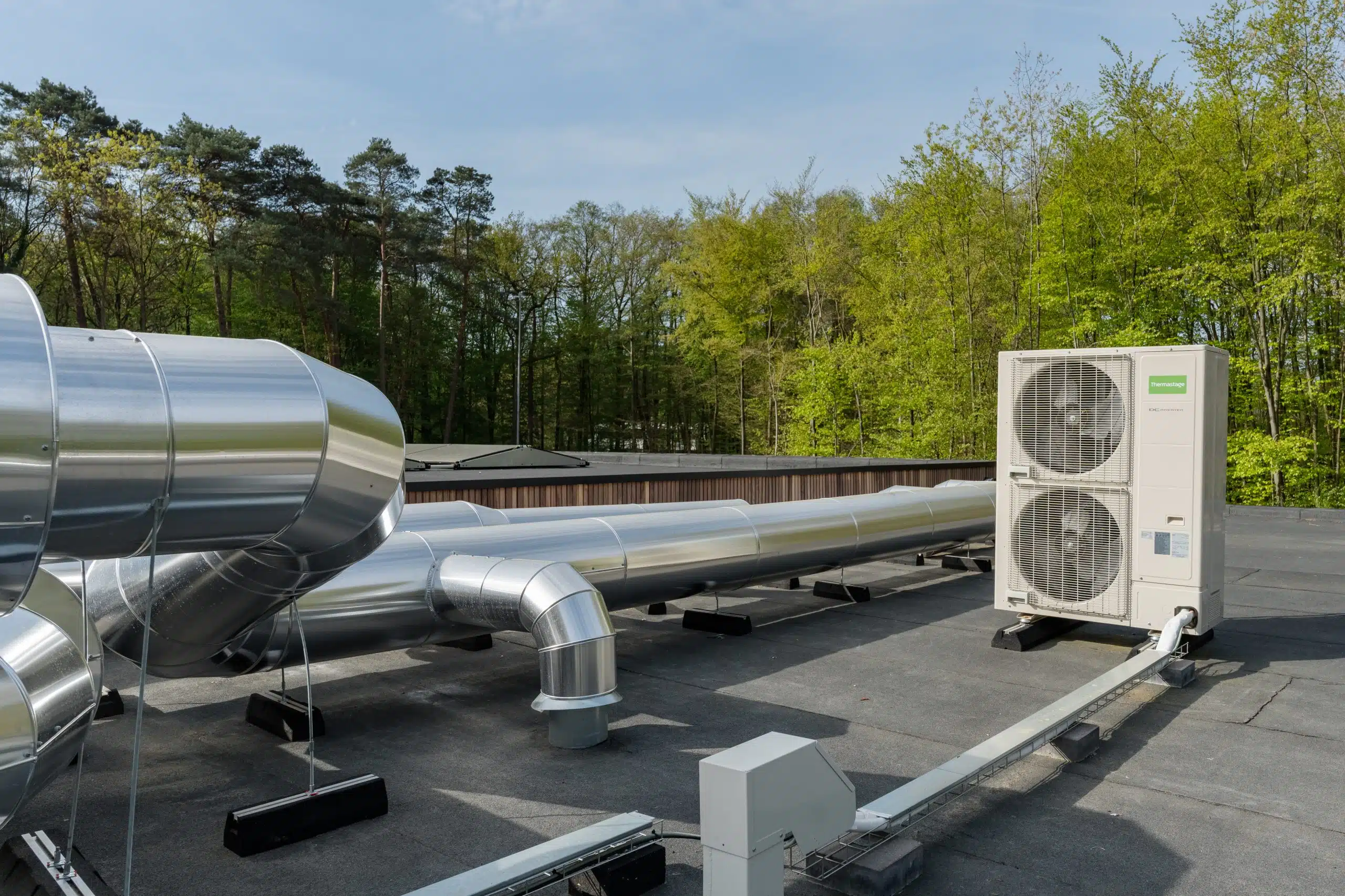 Airco warmtepomp installatie met buitenunit en leidingsysteem op dak