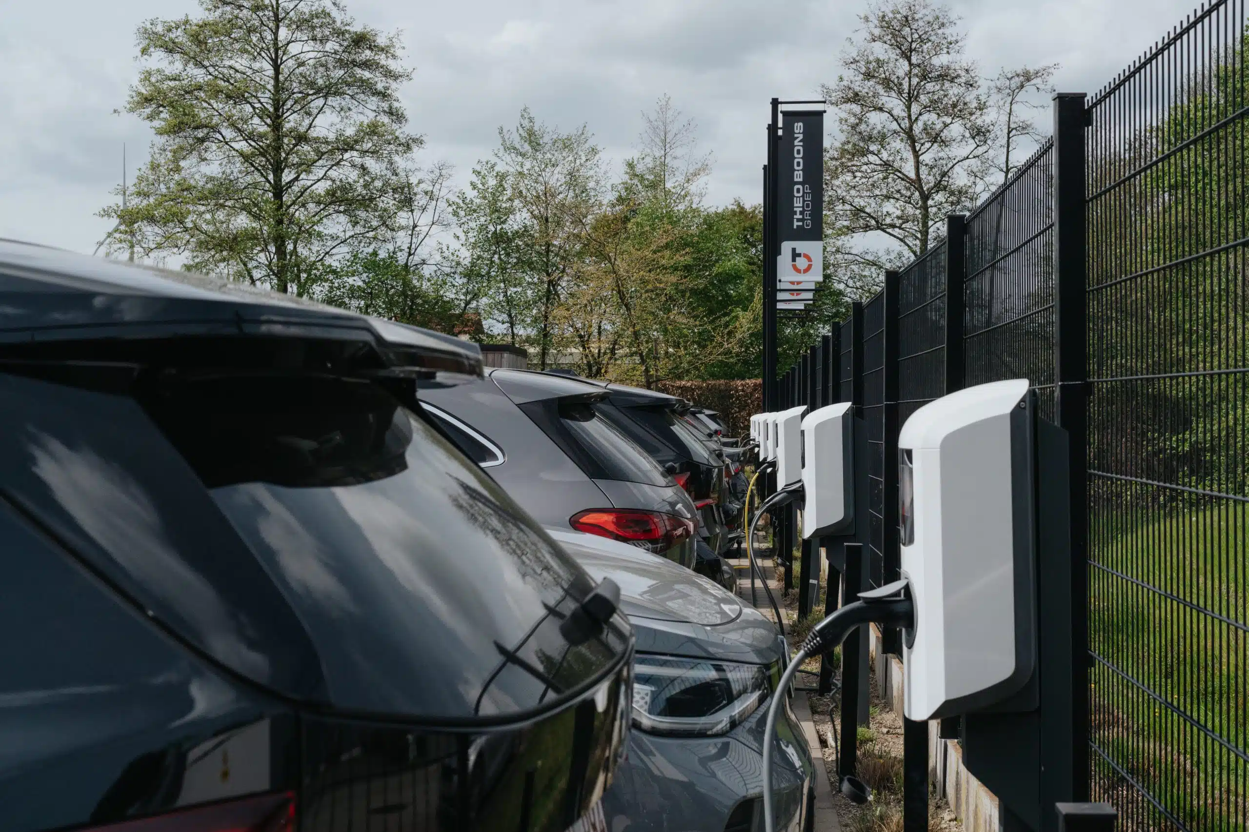 Rij witte laadpalen voor elektrische auto's op een parking.